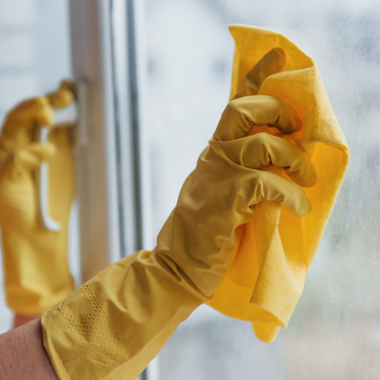 Cleaning window with yellow gloves